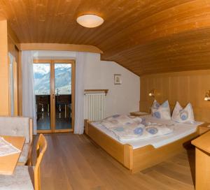 a bedroom with a bed and a large window at Krebishof Agriturismo in Schenna