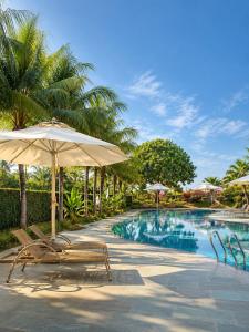 a swimming pool with two chairs and an umbrella at An Velora Boutique Hotel in Lai Nghê (2)
