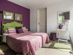 ポンタ・デルガダにあるCasa Vitorianaの紫の壁の緑のベッドが備わるベッドルーム1室が備わります。