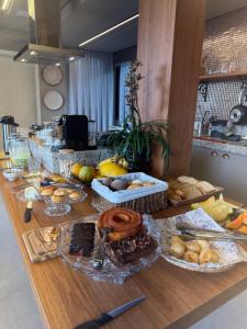a table with many different types of food on it at Suíte Boutique 302 Cheia de Graça in Divinópolis