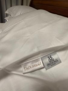 a white bed with a hospital tag on it at Suíte Boutique 302 Cheia de Graça in Divinópolis
