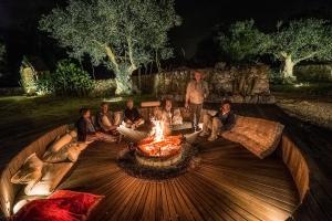 a group of people sitting around a fire pit at Masseria Trulli&Stelle B&B in Noci