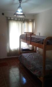 1 dormitorio con 2 literas y ventana en Pequeña Villa en San Rafael