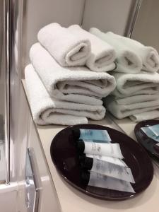 a pile of towels on a counter in a bathroom at Central Cambridge House in Cambridge