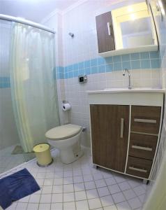 y baño con aseo, lavabo y ducha. en Apartamento Bombas, en Bombinhas