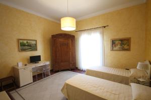a bedroom with two beds and a desk with a computer at Tenute Piazza Countryhouse in Ribera