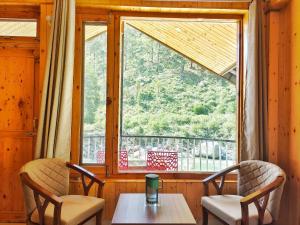 a room with a table and chairs and a window at Riverside Bliss Cottages in Gushaini