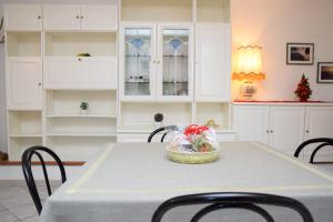 a kitchen with a table with chairs and white cabinets at Casa Galoppa in Trevi