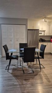 a dining room with a table and chairs and a kitchen at Messila in Gatineau +2 photos