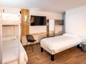a bedroom with two beds and a desk and a television at ibis Styles Brive Ouest in Brive-la-Gaillarde +59 photos