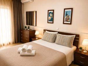 a bedroom with a bed with two towels on it at Stasa Luxury Apartments in Keramoti