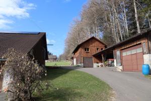 a couple of barns with a driveway and a garage at Stöckli aux Fontaines in Tramelan