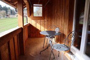 a porch with a table and chairs in a cabin at Stöckli aux Fontaines in Tramelan
