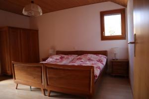 a bedroom with a bed with a wooden frame and a window at Stöckli aux Fontaines in Tramelan
