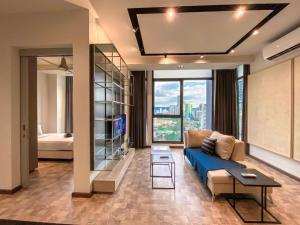 a living room with a blue couch and a large window at Expressionz Suites, 300mbps Wifi, near KLCC, IJN by Wodages in Kuala Lumpur