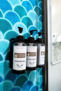 three bottles of soap are sitting on a shelf at Rasgrand in Rasdhoo