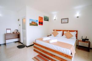 a bedroom with a bed and a desk in a room at Elee Villa - Waterfront Retreat with Victoria Reservoir & Mountain Views in Teldeniya