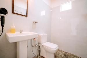 a bathroom with a white toilet and a sink at Elee Villa - Waterfront Retreat with Victoria Reservoir & Mountain Views in Teldeniya +115 photos