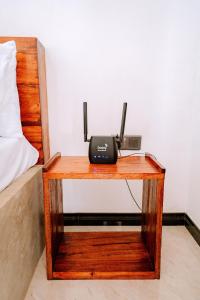 a wooden table with a phone on it next to a bed at Elee Villa - Waterfront Retreat with Victoria Reservoir & Mountain Views in Teldeniya
