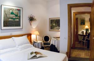 
a hotel room with a bed, desk, and mirror at Hotel Locanda Cairoli in Rome
