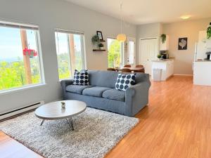 a living room with a couch and a table at Ravenwood Stay With Ocean View in Victoria