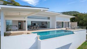 a white house with a swimming pool at Rockstarvillas Grande Siesta in Nathon Bay