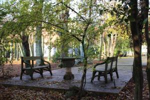 two benches and a fountain in a park with trees at Villa Merenciana in Agoncillo