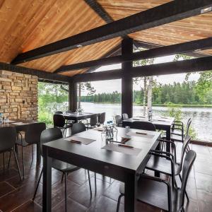 a dining room with tables and chairs and a large window at Rapukartano in Mänttä