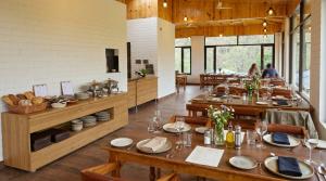 a large dining room with wooden tables and chairs at Corbett Retreat in Rāmnagar