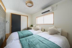 two beds in a small room with a window at Building D - Vacation STAY 84939v in Bōchū