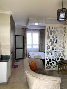 a living room with a couch and a bed at Modern Airport Studio apartment 5 mins to JKIA &SGR,Fast Wi-Fi,Ideal for layovers and longstays in Nairobi