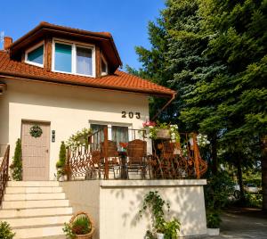 a house with a table and chairs on the balcony at KRK stop near airport in Cholerzyn