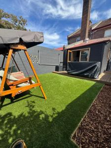 a swing on the grass in a backyard at Charm on Forster in Invermay