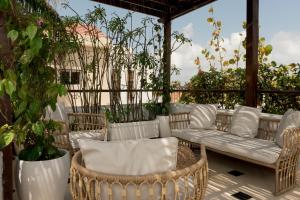 a patio with wicker chairs and a couch at Amarla Boutique Hotel Cartagena in Cartagena de Indias