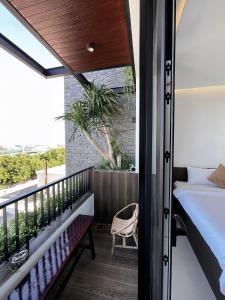 a room with a balcony with a bed and a window at The SeaNest Home - Làng Chài Mỹ Tân Ninh Thuận in Vinh Hai