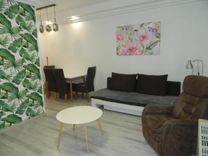 a living room with a couch and a table at Héli apartman in Hajdúszoboszló