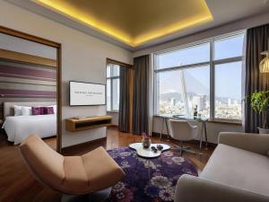a hotel room with a bed and a tv at Grand Mercure Danang - 10 minutes to Airport & 200m to Bach Dang Walking street in Danang