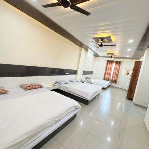 a bedroom with two beds and a ceiling at Hotel Shyam Mahal Inn in Khātu