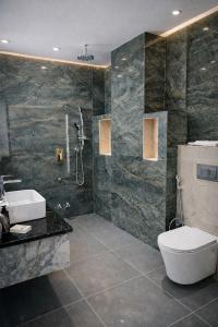 a bathroom with a toilet and a sink and a shower at Hotel Hider in Gurgaon +27 photos