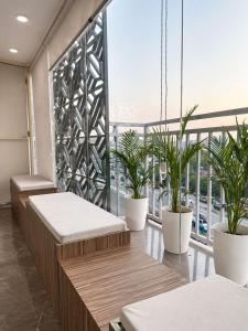 a room with benches and potted plants on a balcony at Hotel Hider in Gurgaon