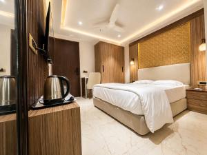 a hotel room with a bed and a television at Hotel Hider in Gurgaon