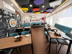 a restaurant with tables and chairs and a chalkboard wall at Hotel Hider in Gurgaon