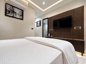 a bedroom with a large bed with a flat screen tv at Hotel Hider in Gurgaon