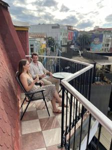 Hotel Boutique Casa Vander في فالبارايسو: رجل وامرأة يجلسان على شرفة