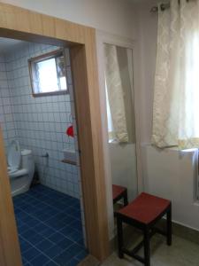 a bathroom with a toilet and a window at The Boulevard Hotel in Jamshedpur