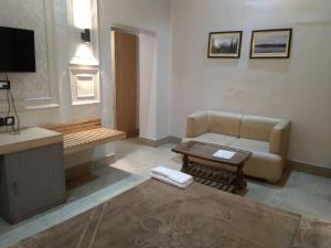 a living room with a couch and a table at The Boulevard Hotel in Jamshedpur +65 photos