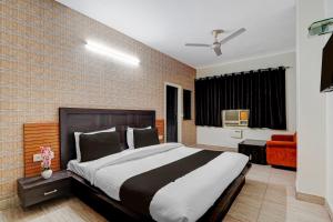 a bedroom with a large bed and a brick wall at Super Hotel O by OYO Clock Tower Ludhiana Formerly Greatwall in Ludhiana +28 photos