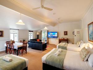 ein Hotelzimmer mit zwei Betten und einem Wohnzimmer in der Unterkunft Maleny Hotel in Maleny