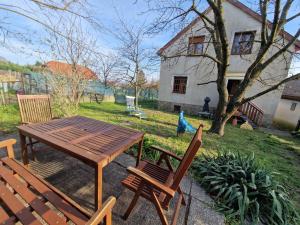 a picnic table and chairs in a yard with a house at Réhelyi in Szigliget