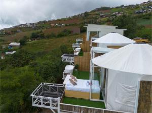 a room with chairs and an umbrella on a hill at ชาเลต์ ภูทับเบิก in Ban Maeo Thap Boek